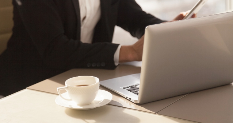 Recruiter arbeitet am Laptop im Büro mit Kaffee am Arbeitsplatz