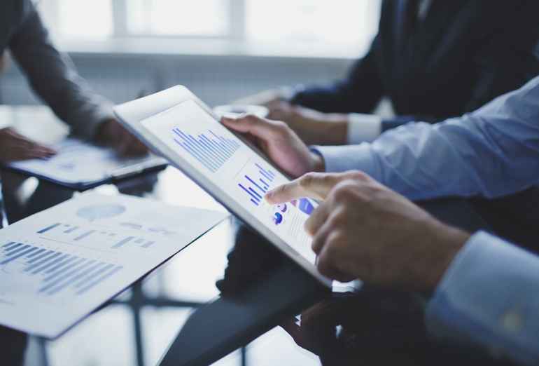 Analyse von Geschäftsdaten auf Tablet während eines Business-Meetings